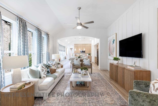27019 Golden Isle Ln, Katy, TX 77493 - living area with ceiling fan, arched walkways, light wood finished floors, baseboards, and lofted ceiling