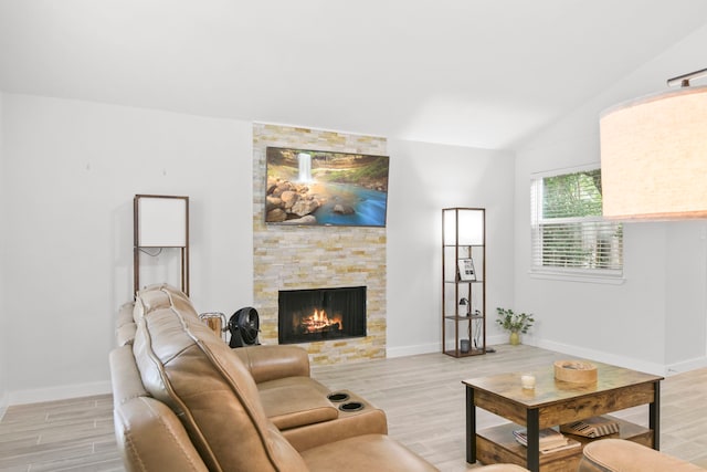 17907 Wolf Hollow Dr, Houston, TX 77084 - living room featuring a stone fireplace, light wood finished floors, lofted ceiling, and baseboards