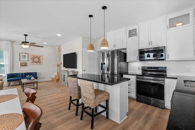130 Beachcomber Ave, Surfside Beach, TX 77541 - kitchen with stainless steel appliances, decorative backsplash, white cabinetry, light wood-style flooring, and recessed lighting