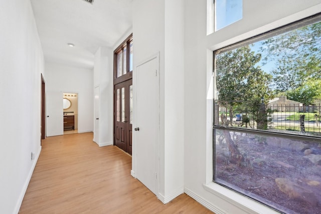 7202 Las Brisas Dr, Houston, TX 77083 - hall featuring a high ceiling, light wood-type flooring, healthy amount of natural light, and baseboards