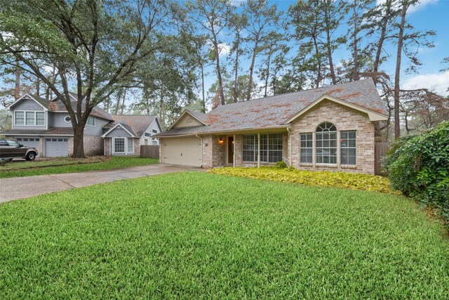36 N Rain Forest Ct, Spring, TX 77380 - view of front of house with concrete driveway, brick siding, a front yard, and an attached garage