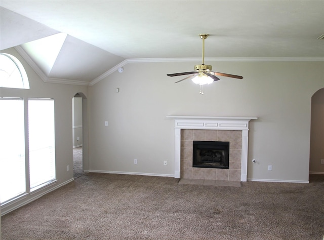 22922 Still Pond Dr, Tomball, TX 77375 - unfurnished living room featuring arched walkways, a ceiling fan, a tiled fireplace, carpet flooring, and vaulted ceiling