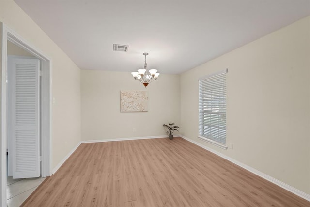 9039 Sandstone St, Houston, TX 77036 - empty room with light wood finished floors, a chandelier, and baseboards