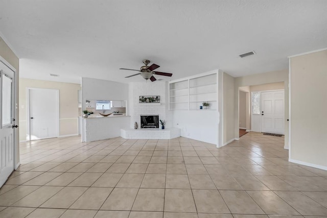 9039 Sandstone St, Houston, TX 77036 - unfurnished living room featuring light tile patterned floors, ceiling fan, a brick fireplace, baseboards, and built in features