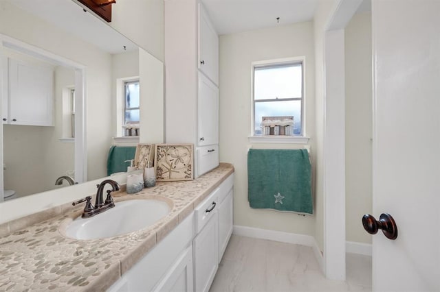 9039 Sandstone St, Houston, TX 77036 - bathroom featuring vanity, baseboards, marble finish floors, and toilet
