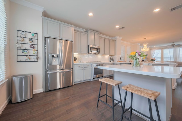 10712 Addicks Oaks Pl, Houston, TX 77043 - kitchen with appliances with stainless steel finishes, dark wood finished floors, a center island, light countertops, and a kitchen breakfast bar