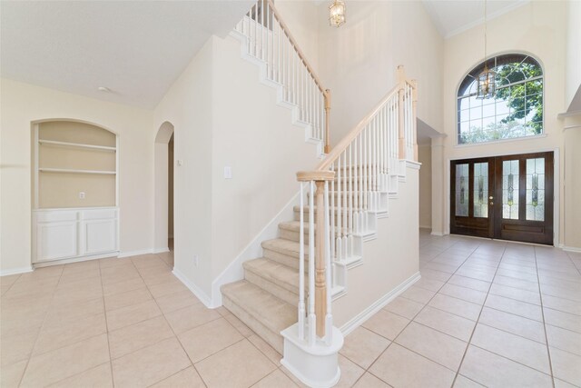 12236 S Shadow Cove Dr, Houston, TX 77082 - tiled foyer with stairs, a towering ceiling, arched walkways, and baseboards