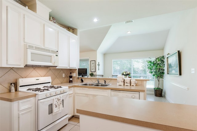 1511 Ashley Ct, Tomball, TX 77375 - kitchen with white appliances, a sink, a peninsula, light tile patterned floors, and decorative backsplash
