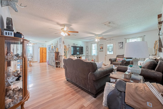 200 Little Pine Valley Rd, Cleveland, TX 77328 - living area with a ceiling fan, light wood-type flooring, a textured ceiling, and healthy amount of natural light
