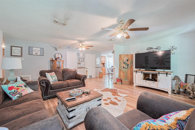 200 Little Pine Valley Rd, Cleveland, TX 77328 - living room with ceiling fan, light wood-style floors, and a textured ceiling