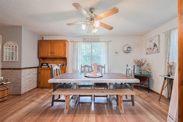 200 Little Pine Valley Rd, Cleveland, TX 77328 - dining area with a textured ceiling, ceiling fan, light wood-style flooring, and a wainscoted wall