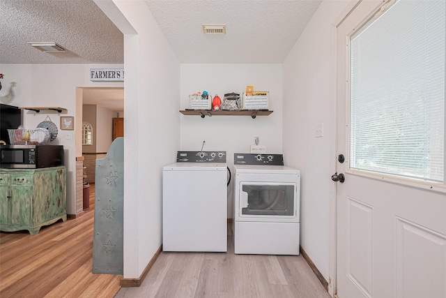 200 Little Pine Valley Rd, Cleveland, TX 77328 - washroom featuring washer and dryer, light wood-type flooring, and a textured ceiling