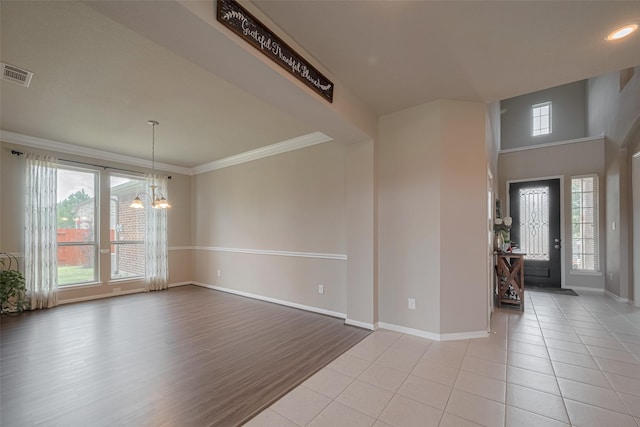 25203 Azel Shore Ct, Porter, TX 77365 - entrance foyer with a chandelier, healthy amount of natural light, crown molding, and light tile patterned floors