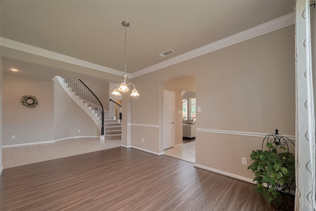 25203 Azel Shore Ct, Porter, TX 77365 - unfurnished room featuring wood finished floors, stairs, arched walkways, and crown molding