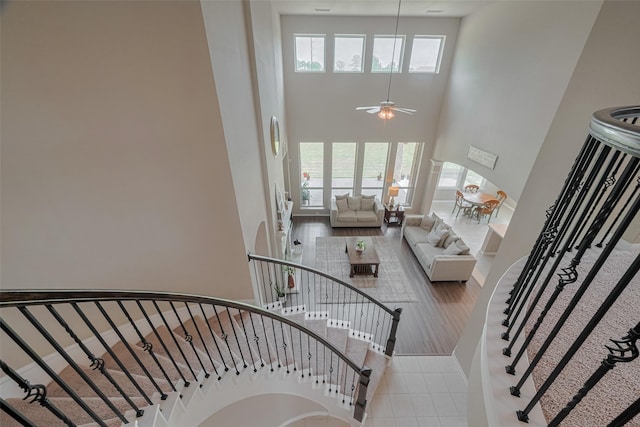 25203 Azel Shore Ct, Porter, TX 77365 - stairway with a towering ceiling, a ceiling fan, and wood finished floors