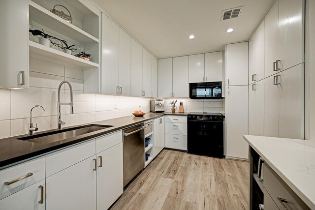 2200 Willowick Rd Unit 4E, Houston, TX 77027 - kitchen featuring black appliances, a sink, open shelves, light wood finished floors, and backsplash