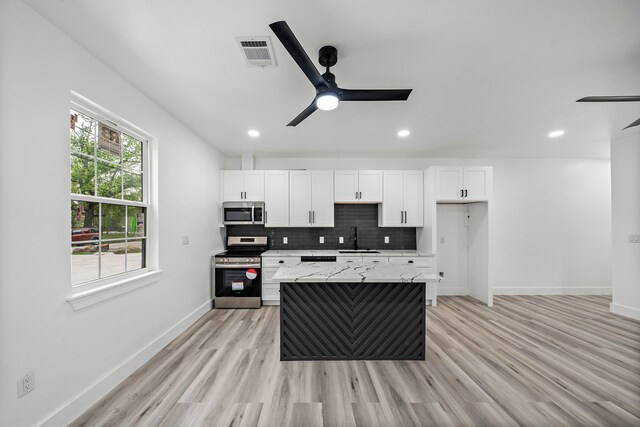 8209 Richland St A/B, Unit A/B Houston, TX 77028 - kitchen with stainless steel appliances, ceiling fan, a sink, white cabinetry, and recessed lighting