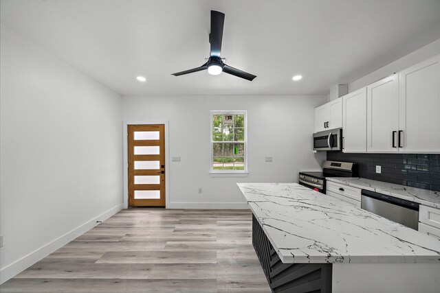 8209 Richland St A/B, Unit A/B Houston, TX 77028 - kitchen with appliances with stainless steel finishes, recessed lighting, white cabinets, ceiling fan, and decorative backsplash
