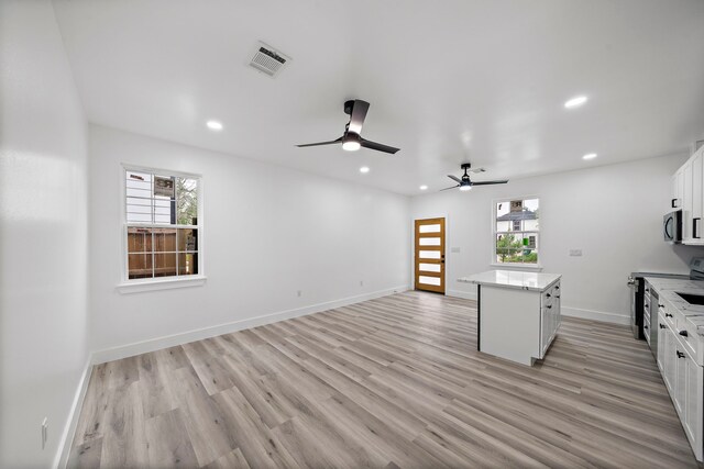 8209 Richland St A/B, Unit A/B Houston, TX 77028 - kitchen with stainless steel appliances, a ceiling fan, plenty of natural light, white cabinetry, and recessed lighting