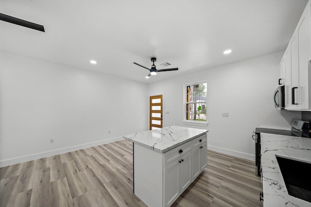 8209 Richland St A/B, Unit A/B Houston, TX 77028 - kitchen featuring stainless steel appliances, light wood finished floors, white cabinets, light stone countertops, and a center island
