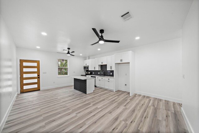 8209 Richland St A/B, Unit A/B Houston, TX 77028 - kitchen with stainless steel microwave, a sink, a kitchen island, recessed lighting, and white cabinets