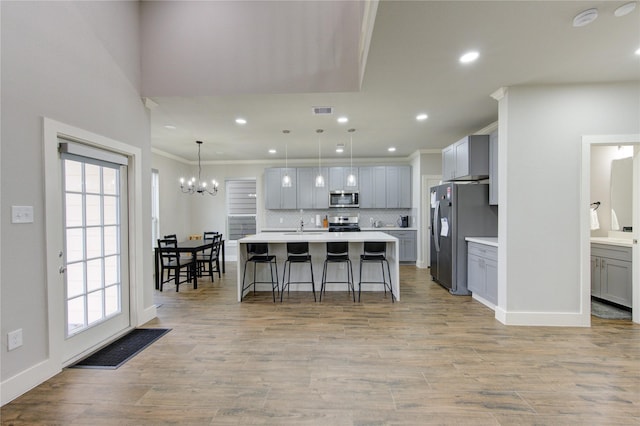 14514 Sanour Dr, Houston, TX 77084 - kitchen featuring appliances with stainless steel finishes, light countertops, a kitchen breakfast bar, decorative backsplash, and a chandelier