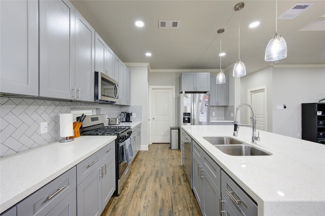 14514 Sanour Dr, Houston, TX 77084 - kitchen with appliances with stainless steel finishes, a sink, crown molding, gray cabinets, and decorative backsplash