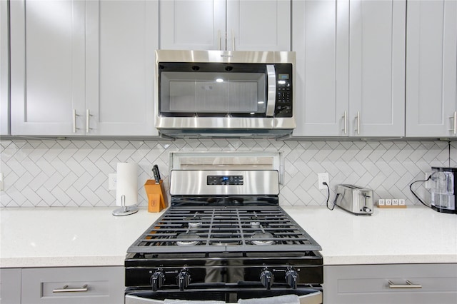 14514 Sanour Dr, Houston, TX 77084 - kitchen featuring stainless steel appliances, tasteful backsplash, gray cabinetry, and light stone countertops