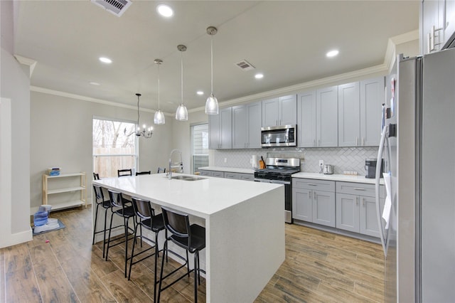 14514 Sanour Dr, Houston, TX 77084 - kitchen featuring stainless steel appliances, a sink, ornamental molding, tasteful backsplash, and an island with sink
