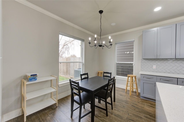 14514 Sanour Dr, Houston, TX 77084 - dining area with a chandelier, dark wood-style flooring, ornamental molding, and baseboards