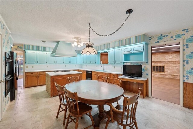 5210 Linda Ln, Beaumont, TX 77708 - kitchen with custom range hood, wallpapered walls, a center island, black appliances, and light countertops