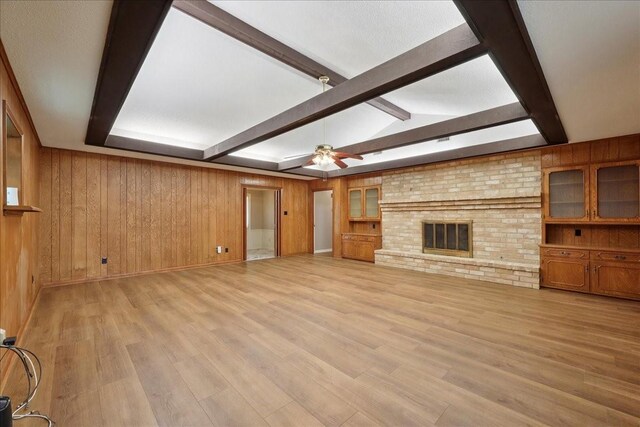 5210 Linda Ln, Beaumont, TX 77708 - unfurnished living room with wood walls, beamed ceiling, light wood-type flooring, ceiling fan, and baseboards
