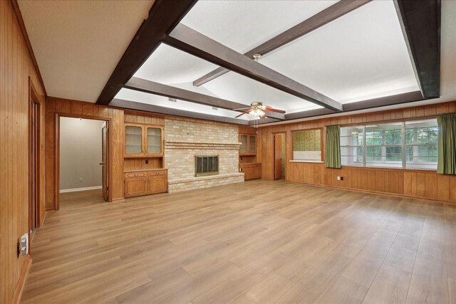5210 Linda Ln, Beaumont, TX 77708 - unfurnished living room featuring wood walls, beam ceiling, ceiling fan, light wood-style floors, and baseboards