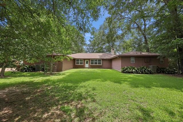 5210 Linda Ln, Beaumont, TX 77708 - rear view of house featuring a lawn, cooling unit, and a chimney