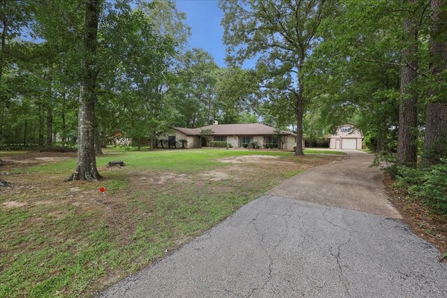 5210 Linda Ln, Beaumont, TX 77708 - ranch-style house featuring asphalt driveway, a front lawn, a garage, and an outdoor structure