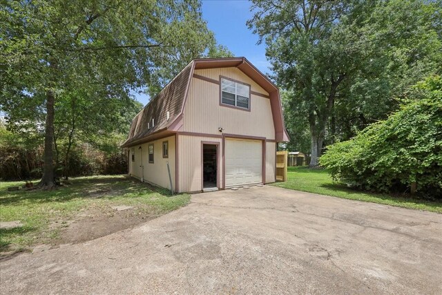 5210 Linda Ln, Beaumont, TX 77708 - view of side of property with a gambrel roof, concrete driveway, and a detached garage