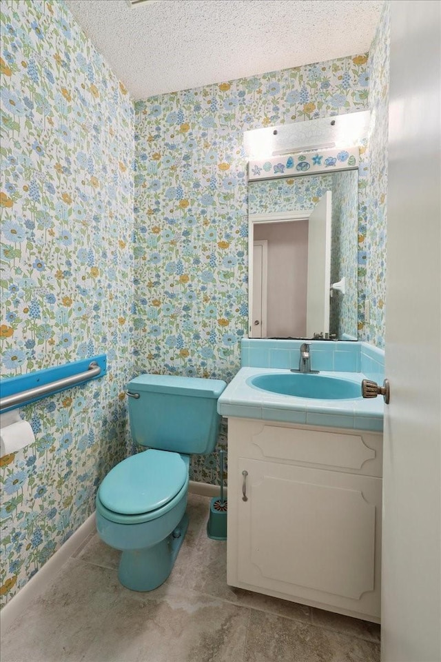 5210 Linda Ln, Beaumont, TX 77708 - bathroom with wallpapered walls, vanity, a textured ceiling, toilet, and baseboards