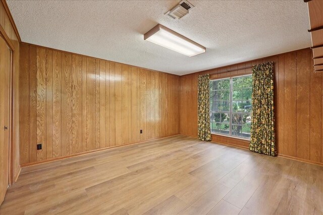 5210 Linda Ln, Beaumont, TX 77708 - unfurnished room featuring wood finished floors, a textured ceiling, wooden walls, and baseboards