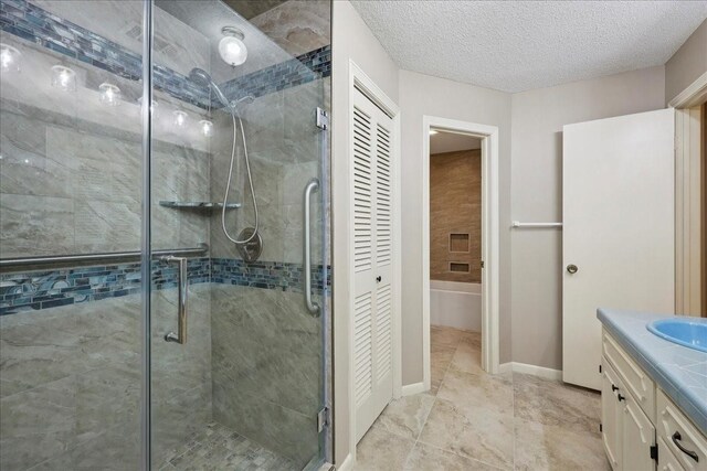 5210 Linda Ln, Beaumont, TX 77708 - full bathroom with a shower stall, vanity, a closet, a textured ceiling, and baseboards