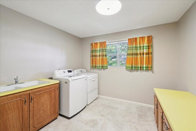 5210 Linda Ln, Beaumont, TX 77708 - laundry area featuring washer and clothes dryer, a sink, a textured ceiling, and baseboards