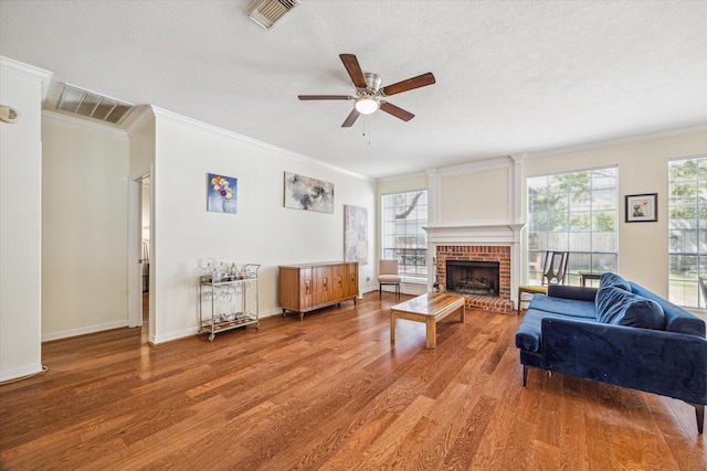 7930 Tizerton Ct, Spring, TX 77379 - living room featuring crown molding, wood finished floors, a ceiling fan, a brick fireplace, and baseboards