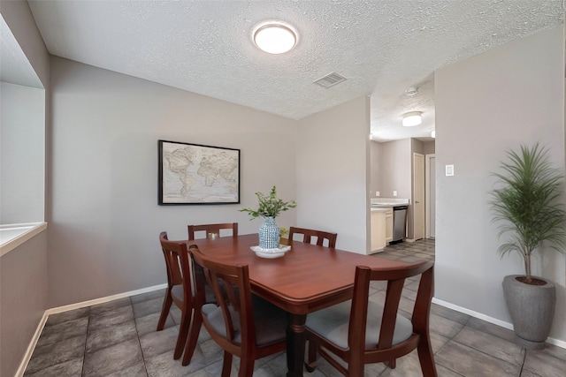 24226 Spring Towne Dr, Spring, TX 77373 - tiled dining area featuring a textured ceiling and baseboards