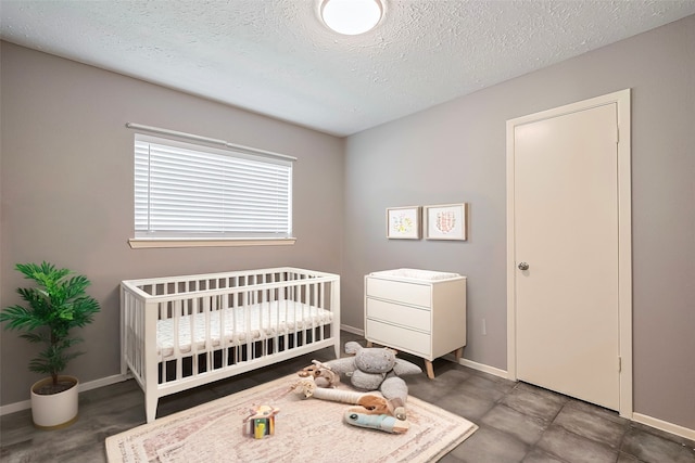 24226 Spring Towne Dr, Spring, TX 77373 - bedroom featuring baseboards, a textured ceiling, and a nursery area