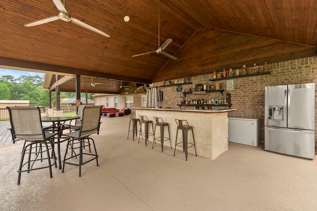 8518 Kerr Dr, Tomball, TX 77375 - community bar area featuring stainless steel refrigerator with ice dispenser, a ceiling fan, wooden ceiling, brick wall, and high vaulted ceiling