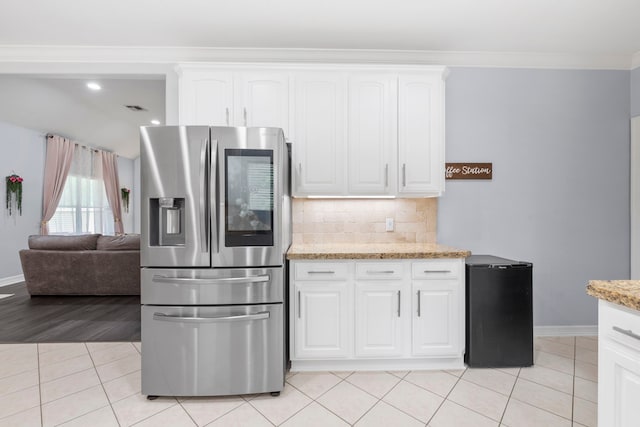 8518 Kerr Dr, Tomball, TX 77375 - kitchen featuring stainless steel refrigerator with ice dispenser, refrigerator, baseboards, light tile patterned floors, and decorative backsplash