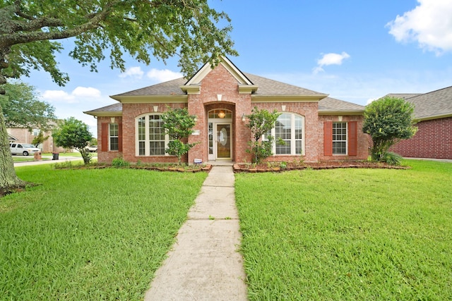 4903 Cedar Cove Dr, Baytown, TX 77521 - view of front of house with a shingled roof, a front lawn, and brick siding