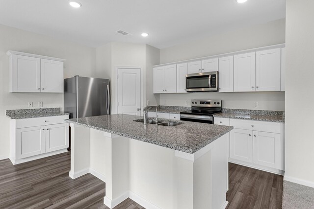 18805 Lucas Michael Way, New Caney, TX 77357 - kitchen with appliances with stainless steel finishes, a sink, an island with sink, white cabinetry, and recessed lighting