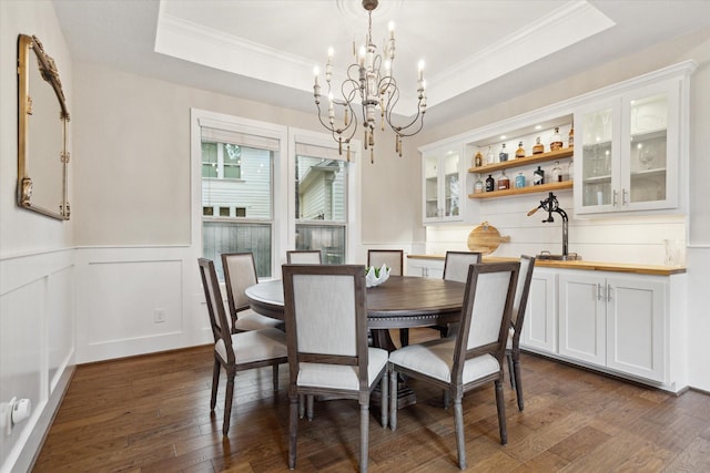 22 Hedgedale Way, Spring, TX 77389 - dining space featuring a chandelier, crown molding, dark wood-style flooring, a wainscoted wall, and a tray ceiling