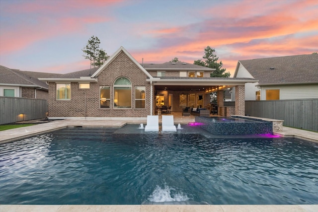 22 Hedgedale Way, Spring, TX 77389 - back of property at dusk featuring brick siding, a fenced backyard, a patio area, and an outdoor hangout area