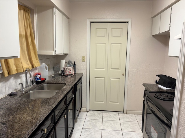 17230 Imperial Valley Dr Unit 24, Houston, TX 77060 - kitchen featuring black / electric stove, a sink, white cabinets, light tile patterned floors, and dark stone counters